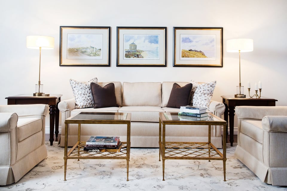 upholstered sofa and two chairs with two small coffee tables over an area rug