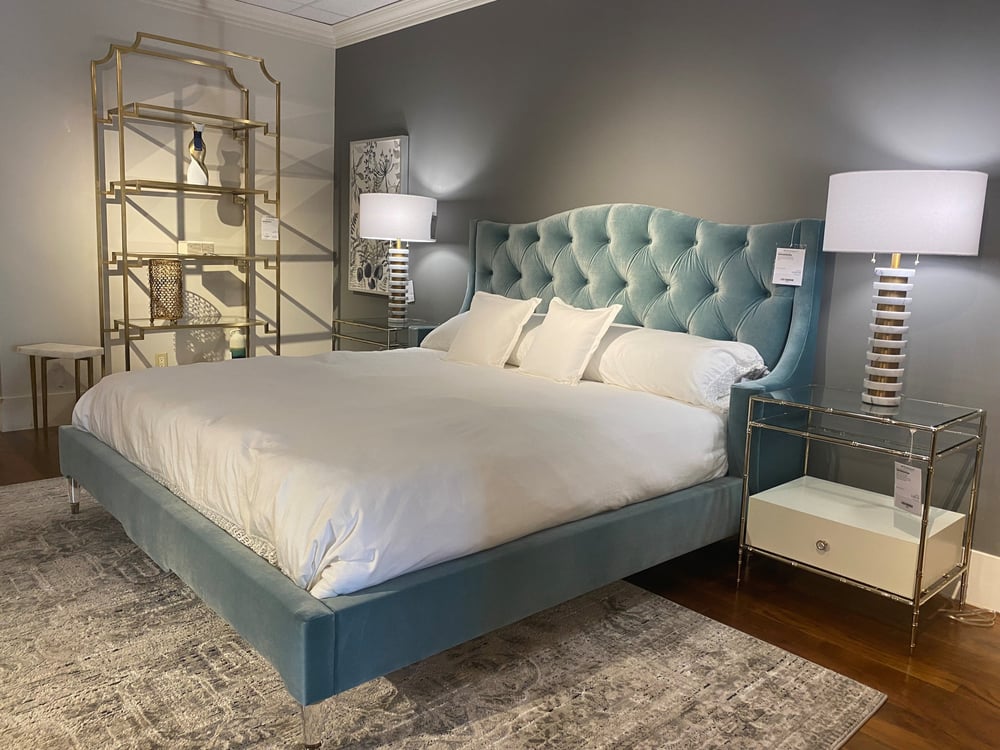 upholstered bed with dressings, two matching nightstands, two matching lamps, an occasional table, and a bookshelf with accessories