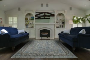 patterned area rug in front of a fire place with two matching sofas