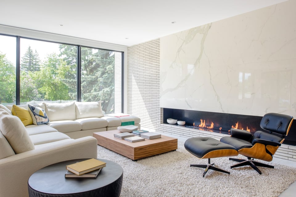 large sectional with leather recliner and ottoman in front of a block coffee table and fireplace