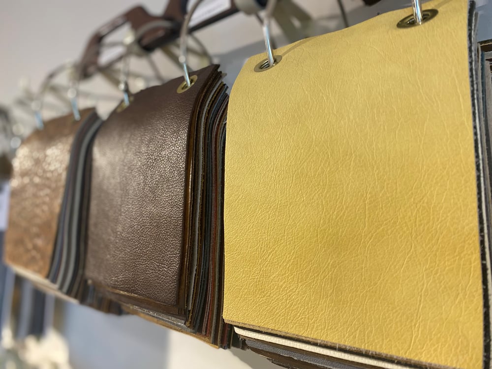 multiple leather samples hang on a wall