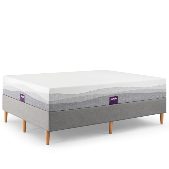 Purple foam mattress over an upholstered foundation with wooden legs