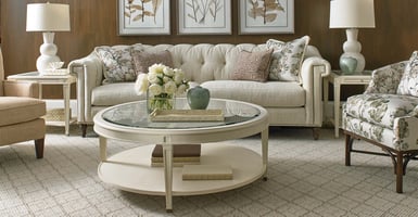 Sherrill Furniture tufted sofa with nail head detailing behind a rounded two tiered coffee table