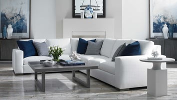 white sectional in living room with coffee table in front of fire place