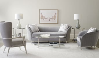 living room scene with a glass oval coffee table and a sofa and two accent chairs