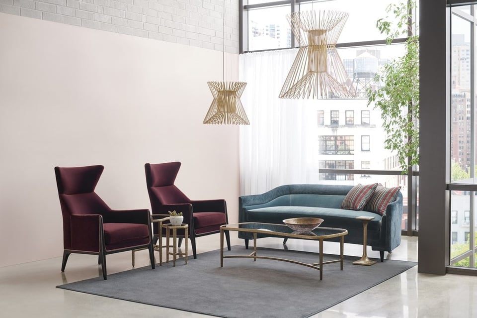 sofa with two accent chairs side by side around a coffee table in front of a window