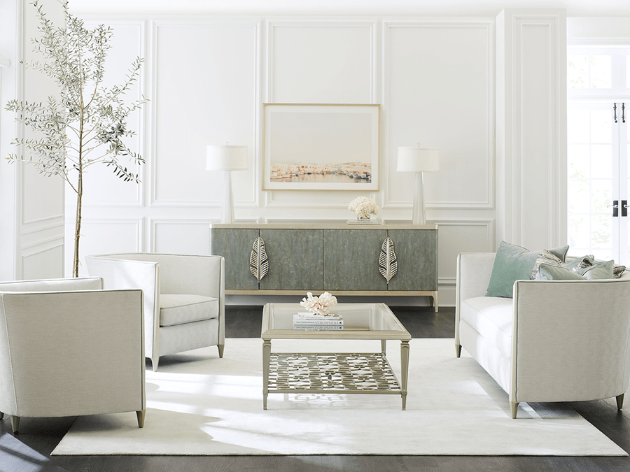 living room scene with a sofa and two chairs around a glass coffee table in front of a credenza with two decorative leaves