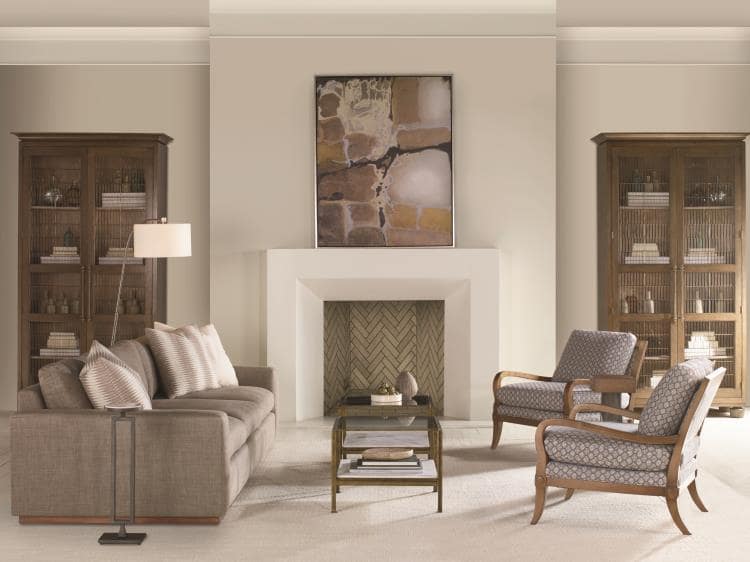 living room setting with deep seated sofa and two matching chairs surrounding a wooden coffee table near a fire place