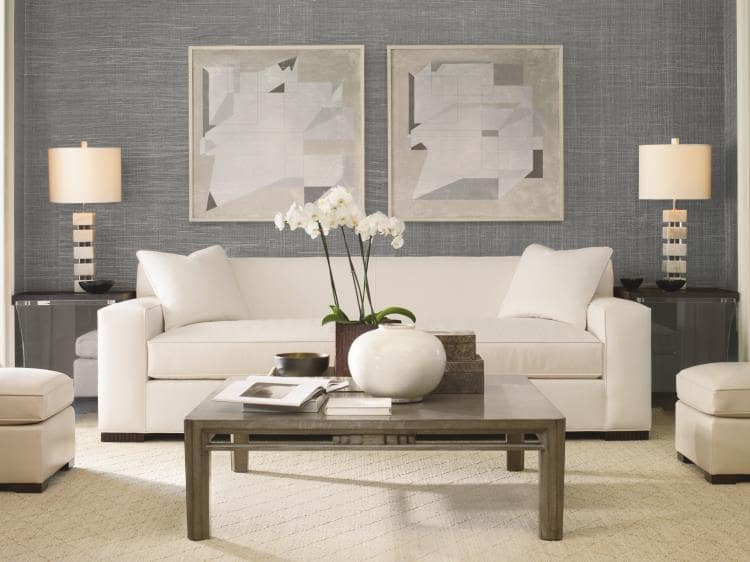 living room setting featuring a sofa with clean lines behind a coffee table, between two matching end tables with lamps