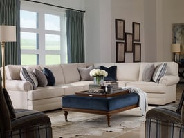 living room with sectional and two accent chairs around an upholstered ottoman with serving tray