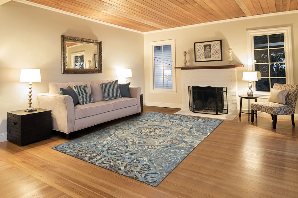 rug in the centre of a living room with a sofa against a wall and a fireplace