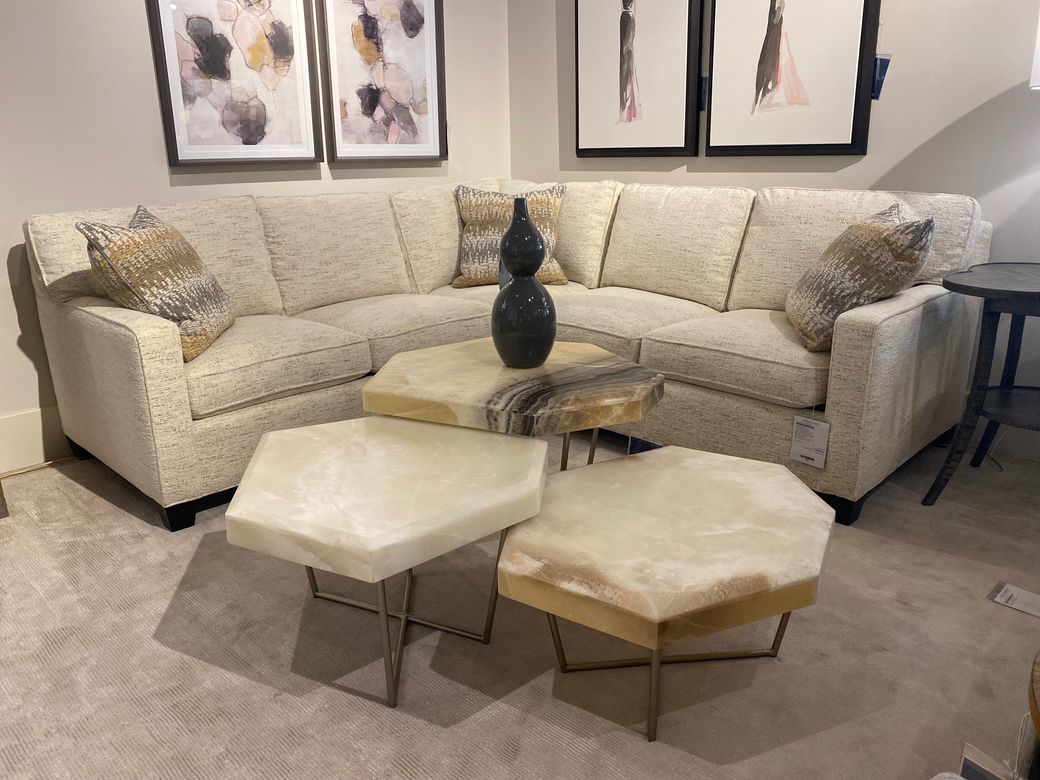 three nesting cocktail tables in front of an l-shaped sectional over  an area rug in a living room setting