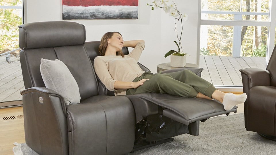woman relaxes and thinks on two seater recliner sofa