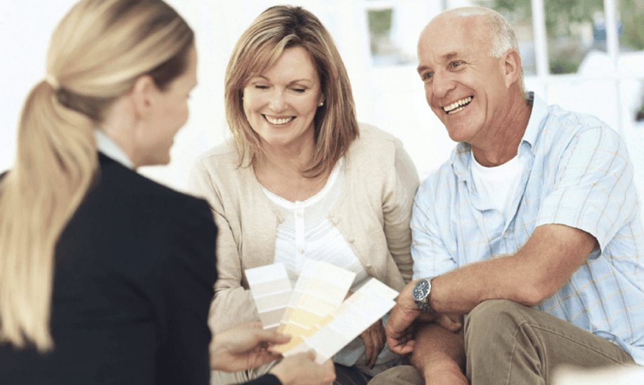 mature couple looks at colour swatches with designer