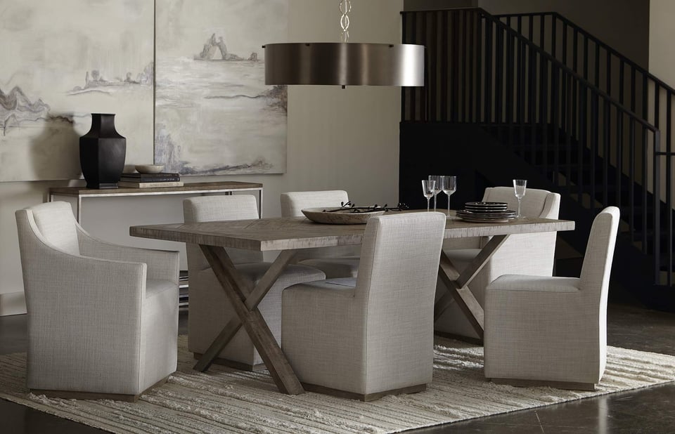 barnboard dining table with six upholstered dining chairs over a neutral area rug