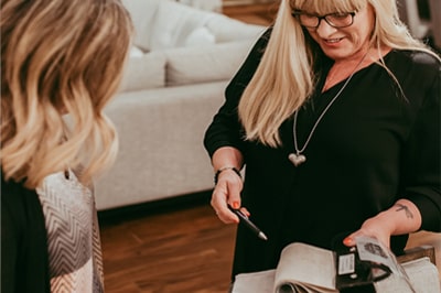 happy woman points out fabric samples to another woman