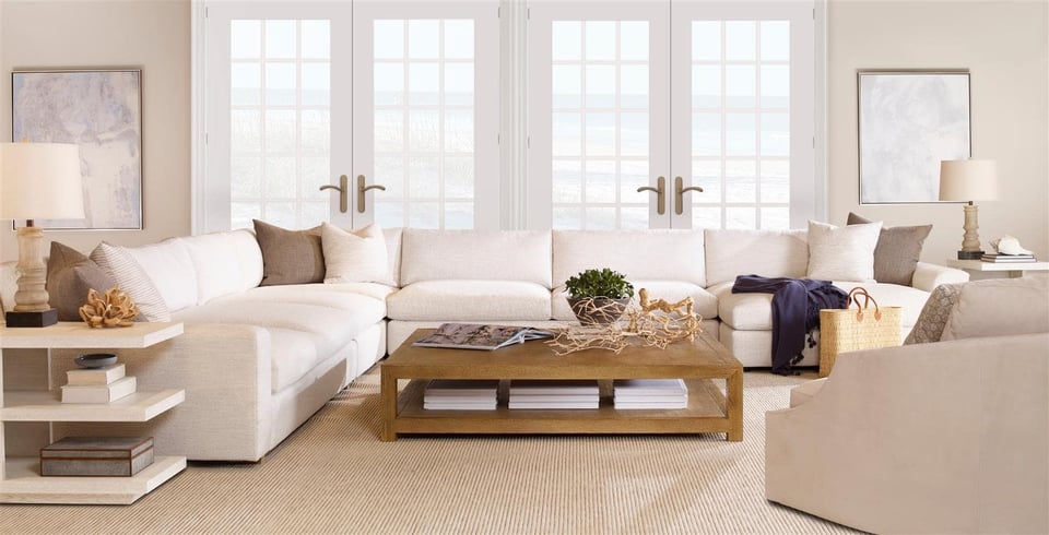 sectional surrounding a wooden coffee table with nearby chair in front of two patio doors