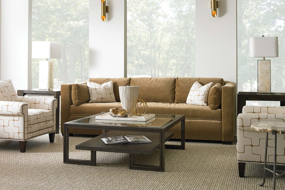 living room with sofa and two pillows that match the two textured and patterned chairs around a two-tiered coffee table