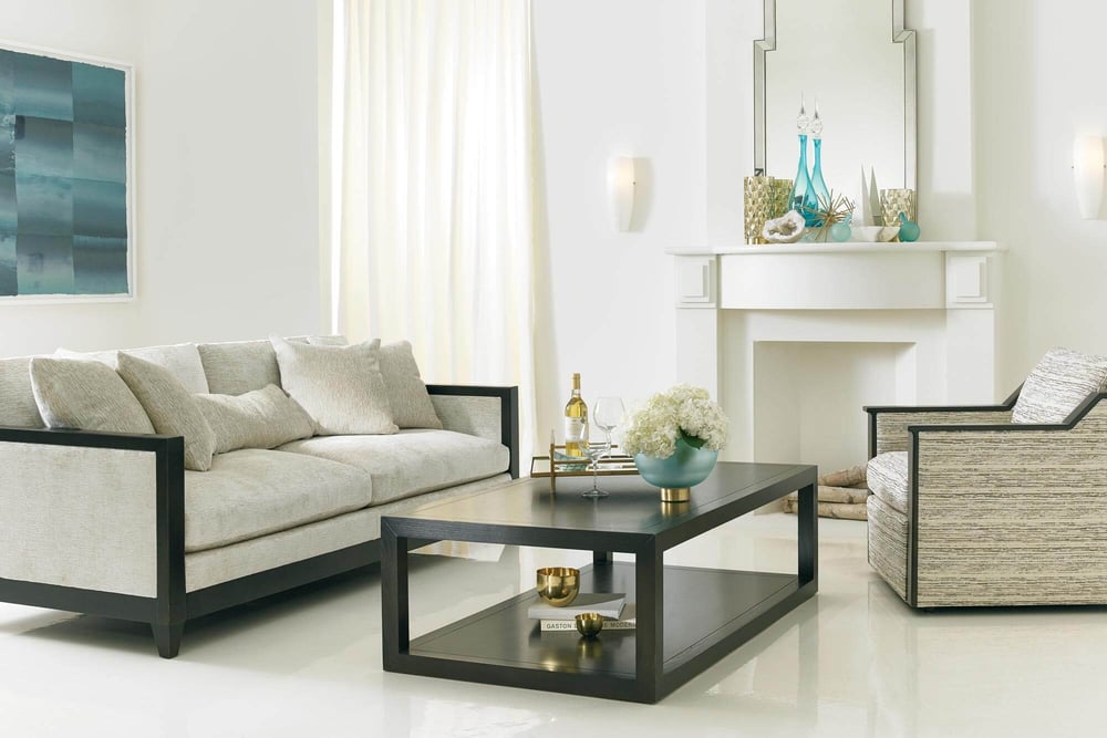 living room of fabric sofa with wood detailing, accent fabric chair with wood detailing and complementary rectangular coffee table near a fireplace