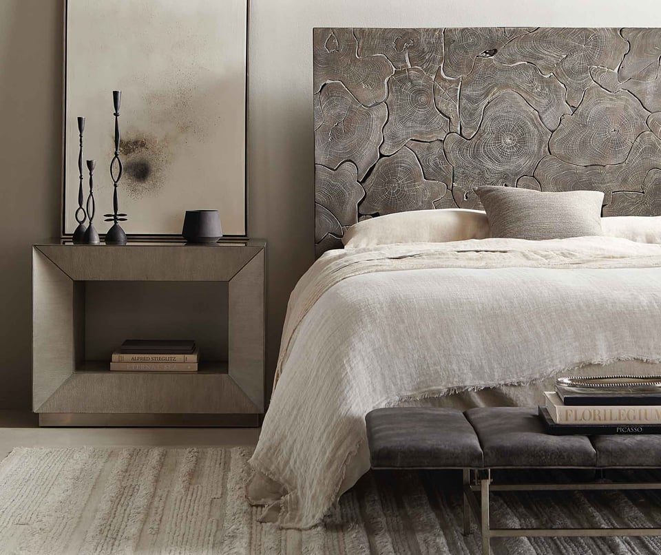 bed with wooden headboard and linens with a rectangular nightstand and iron accessories