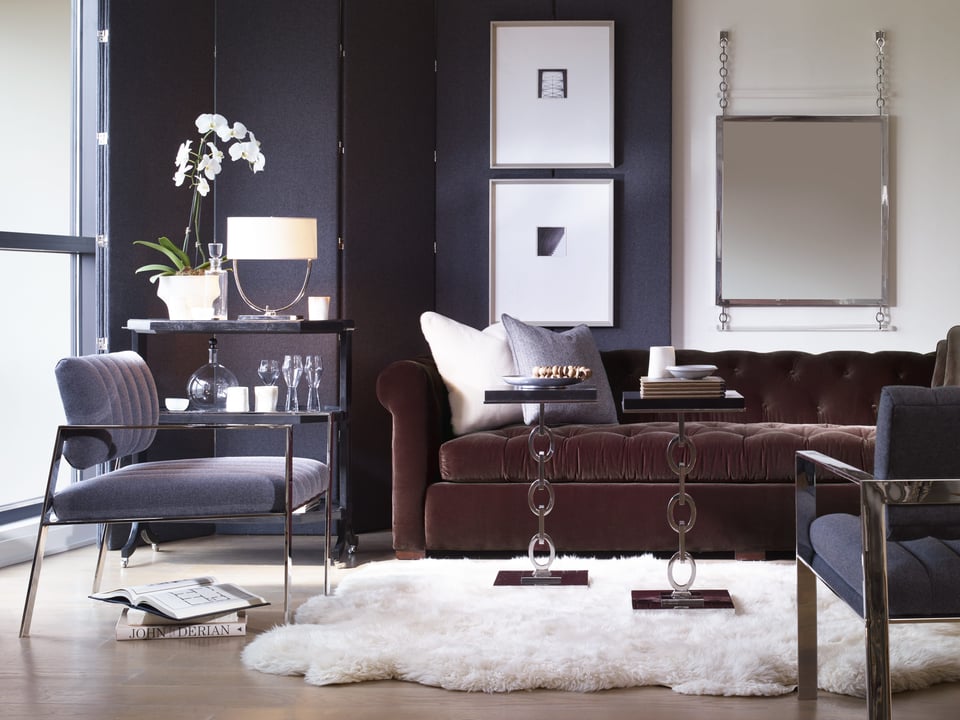 partial living room with tufted sofa and two matching accent chairs with fabric and chrome, drink cart , two small occasional tables over a shag rug