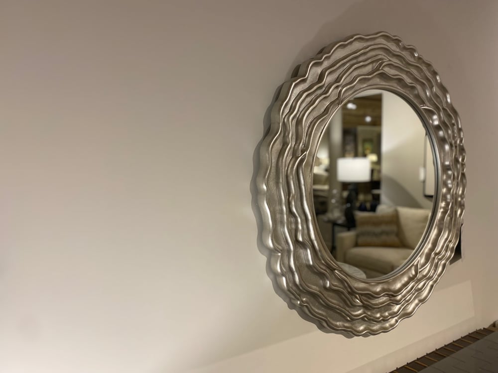 circular mirror with a metallic and curvy frame 