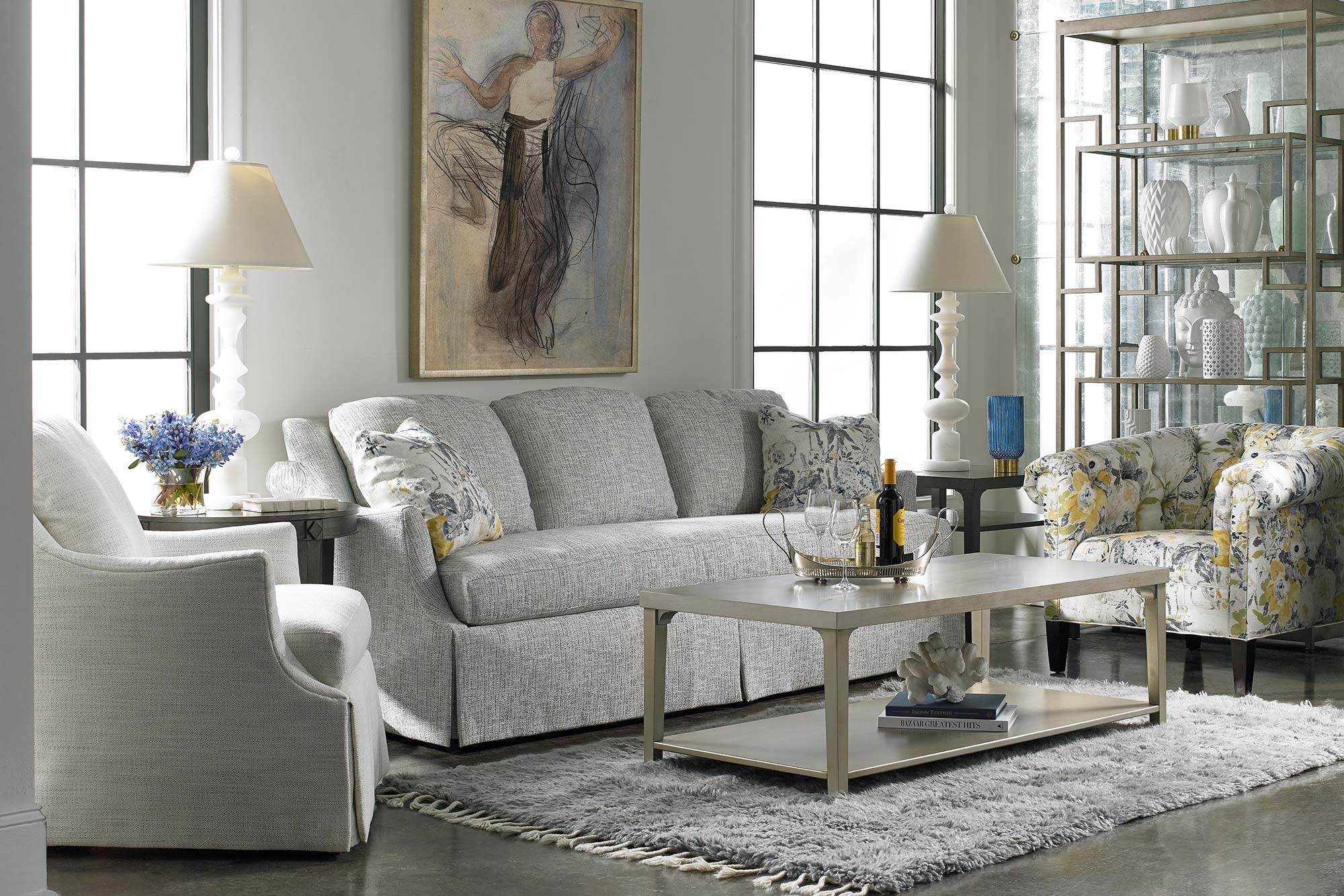 living room with fabric skirted sofa and two accent chairs around a rectangular coffee table over an area rug